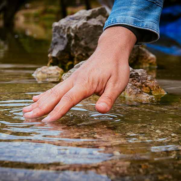 Hand am Wasser