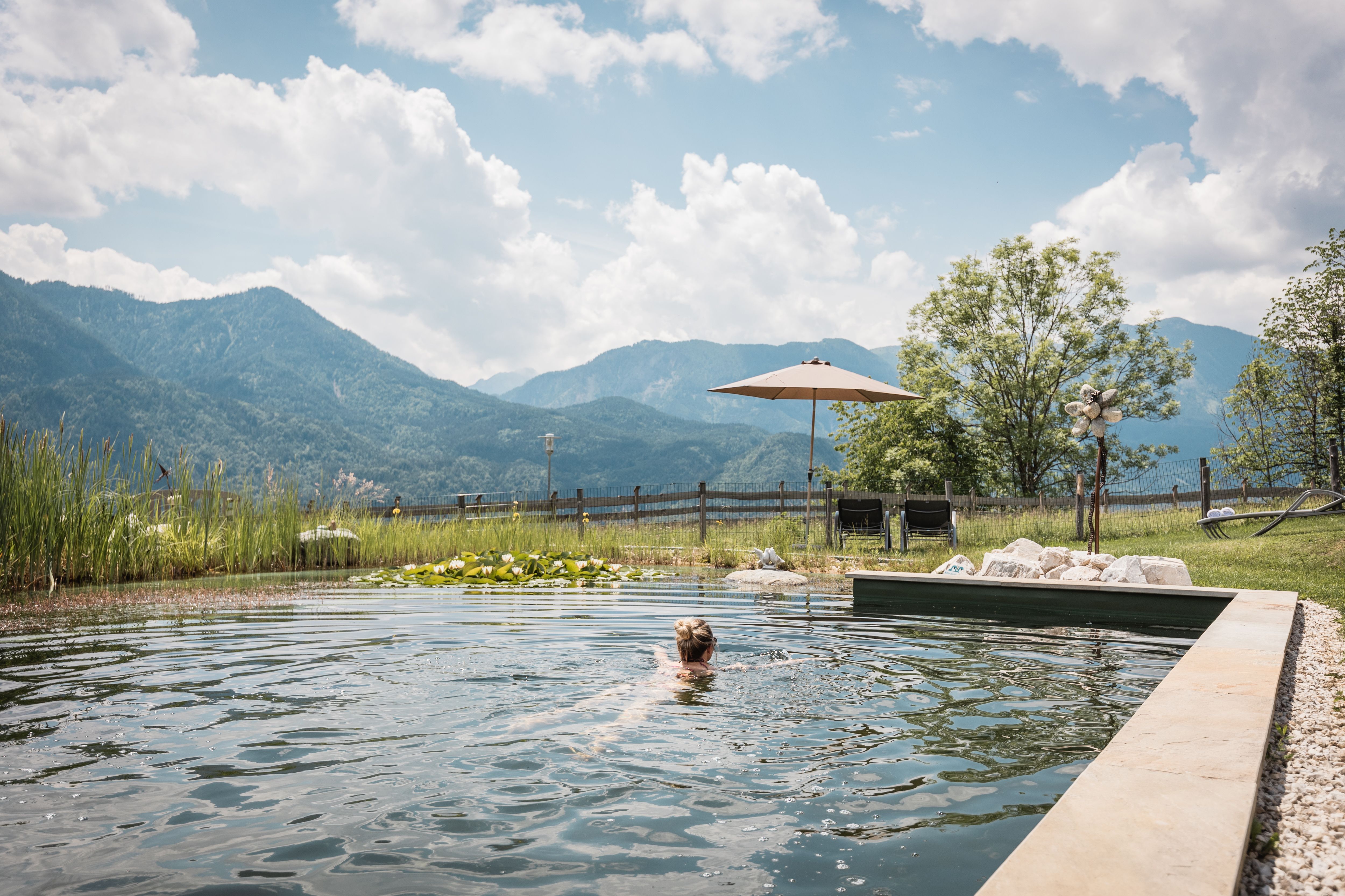 Naturschwimmteich mit schwimmender Person