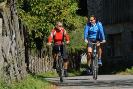 Zwei Radfahrer fahren am Radweg im Drautal