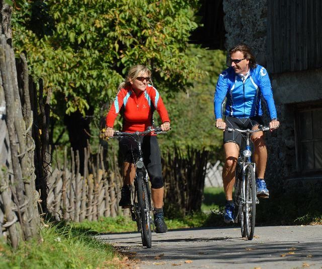 Zwei Radfahrer fahren am Radweg im Drautal