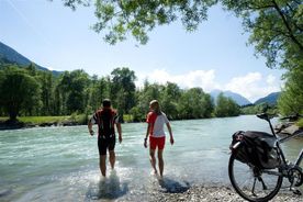Zwei Personen sind mit den Füßen in der Drau