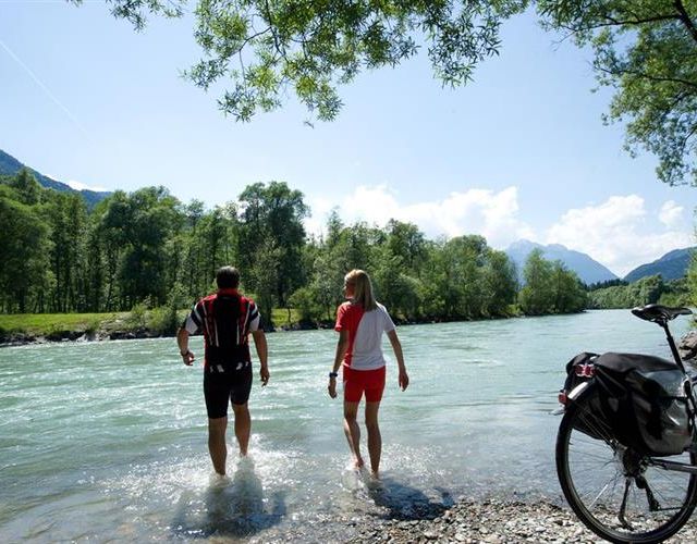 Zwei Personen sind mit den Füßen in der Drau