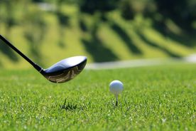 Golfschläger und Golfball im grünen Gras