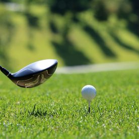 Golfschläger und Golfball im grünen Gras