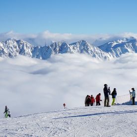 Volle Skipiste mit Bergkulisse