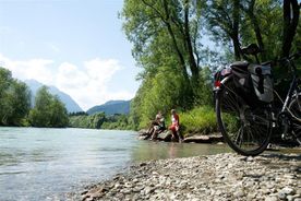 Nach einer Radfahrt entspannen sich die 2 Personen am Wasser