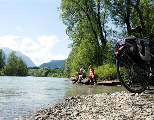 Nach einer Radfahrt entspannen sich die 2 Personen am Wasser